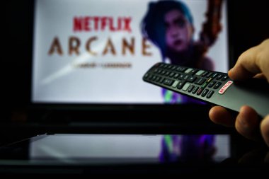 TV uzaktan kumandası ve arka planda Arcane Netflix TV dizisi. Ütopik Pilotlar ve Zaun yeraltı ezilen iki ikonik Lig şampiyonunun kökeni..