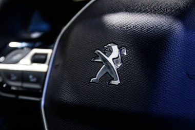 Peugeot şirketinin logosu arabada. Peugeot, Stellantis 'e ait Fransız otomobil markası. Arabadaki aslan logosu.