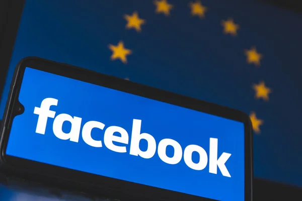 スマートフォンの画面上のFacebookアプリと背景に欧州連合の旗 — ストック写真