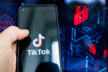 Kaunas, Litvanya - 19 Temmuz 2022: Mobil ekranda TikTok logosu ve güvenlik ve arka planda özel simgeler. TikTok uygulaması ve güvenlik ve özel meseleler