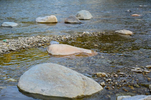stones in the river water .