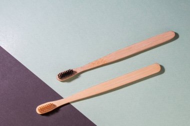 Mavi ve siyah arkaplanda iki bambu diş fırçası var. Ekoloji, diş hijyeni ve sağlık kavramı. Mesaj için yer. Kopyala yapıştır. Yakın plan..