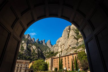 The view of Santa Maria de Montserrat, an abbey of the Order of Saint Benedict located on the mountain of Montserrat in Monistrol de Montserrat, Catalonia, Spain clipart