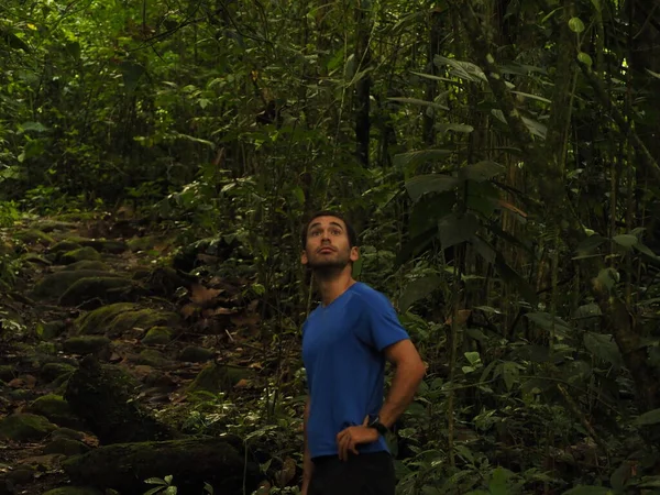 young man hiking in the jungle in costa rica