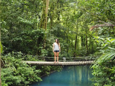 Rio Celeste 'de yürüyüş yapan genç bir kadın.