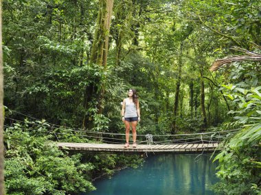 Rio Celeste 'de yürüyüş yapan genç bir kadın.