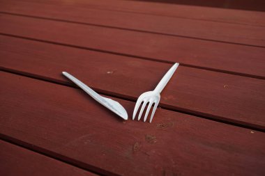 Plastic disposable cutlery on a wooden table