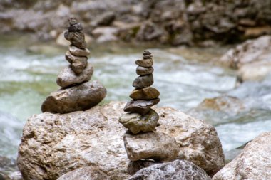 Schwangau, Almanya, 27 Temmuz 2021. Zen tavrı, doğadaki bir nehir boyunca istiflenmiş taşlar..