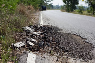 hasarlı kentsel asfalt yol çakıl ile çukur.