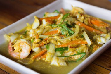 Tabakta köri tozu olan deniz ürünleri..