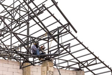 Beyaz arka plandaki inşaat alanında kaynakçı..