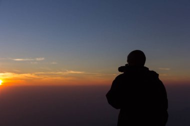 Fotoğrafçı, güneş doğarken manzara fotoğrafı çekiyor..