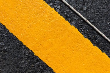 Asfalt yolu soyut arkaplan olarak, yol dokusunda sarı çizgi.