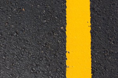 Asfalt yolu soyut arkaplan olarak, yol dokusunda sarı çizgi.
