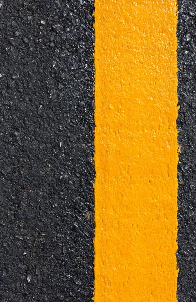Asfalt yolu soyut arkaplan olarak, yol dokusunda sarı çizgi.