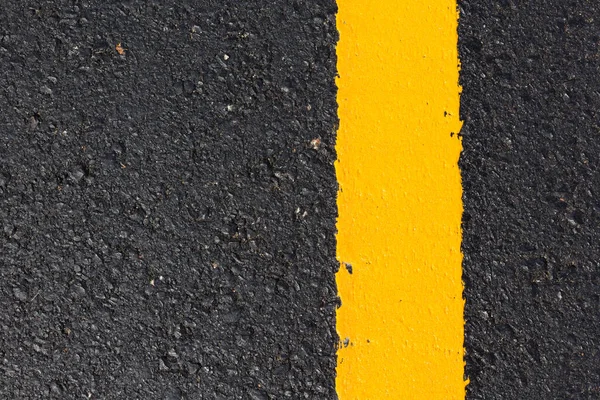 Asfalt yolu soyut arkaplan olarak, yol dokusunda sarı çizgi.