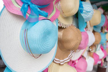 Pazarda asılı duran bayan şapkaları..