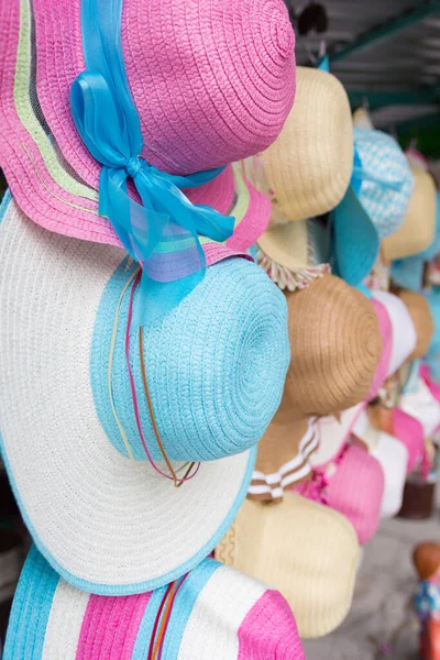 Pazarda asılı duran bayan şapkaları..