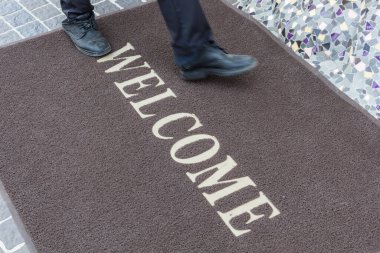 Close up new doormat of welcome text.
