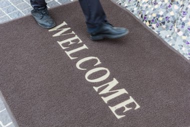 Close up new doormat of welcome text. clipart
