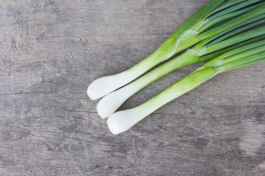 Eski ahşap üzerinde taze soğanlar.