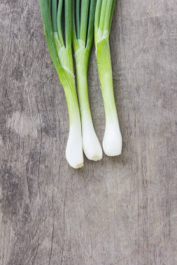 Eski ahşap üzerinde taze soğanlar.