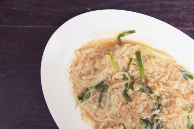 Bir tablo üzerinde kızarmış altın iğne mantar.