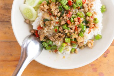 Üzerine kızarmış domuz eti ve ahşap arka planda fesleğen..