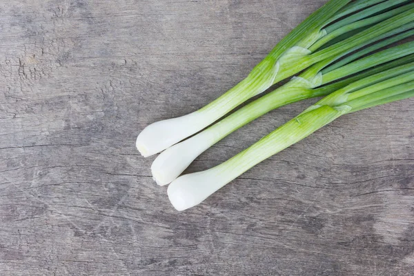 Eski ahşap üzerinde taze soğanlar.