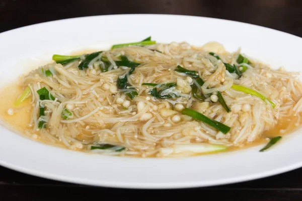 Bir tablo üzerinde kızarmış altın iğne mantar.