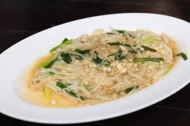 Bir tablo üzerinde kızarmış altın iğne mantar.