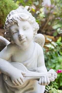 Bahçedeki heykel meleğinin yakın görüntüsü.