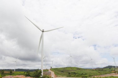 Elektrik üretimi için yeşil çimlerde rüzgar türbini.