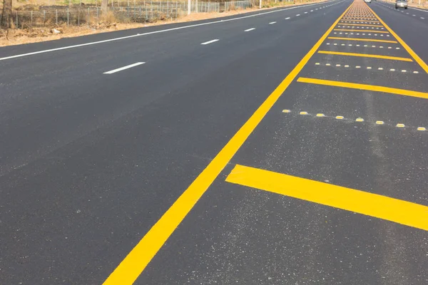 Asfalt yolu soyut arkaplan olarak, yol dokusunda sarı çizgi.
