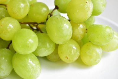 Taze yeşil üzüm meyvesi izole, yeşil arka planda kırpma yolu olan gölge yok.