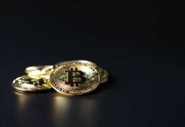 Şifreleme para birimi olarak Bitcoin Sikkeleri siyah arkaplan üzerine yerleştirilmiştir