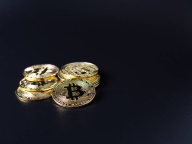 Şifreleme para birimi olarak Bitcoin Sikkeleri siyah arkaplan üzerine yerleştirilmiştir