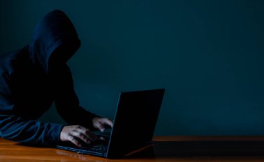 Hacker 'lar karanlıkta dizüstü bilgisayarlarla çalışır. İnternet ağındaki bilgi güvenliği ve bilgi casusluğu kavramı.