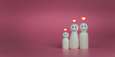 Mutlu ev konsepti. Tahta bebekler kalp simgeleriyle dizilmişler. Evdeki mutluluğu ve aşkı gösterir..