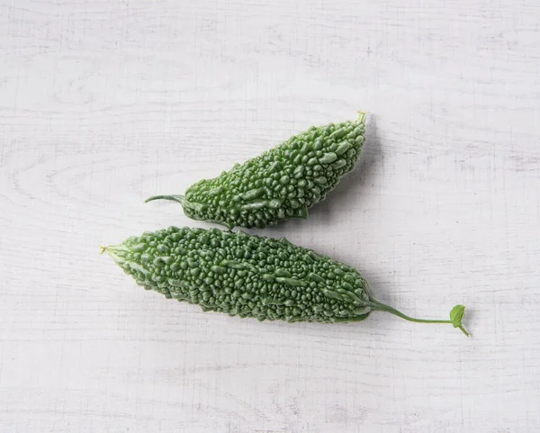 Bitter gourd or bitter melon isolated on white wooden background.