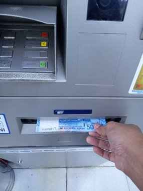 Editör Fotoğrafı, Endonezya, Doğu Jakarta, 02 Ekim 2021, Man Take Money 50000 rupiah ATM BCA
