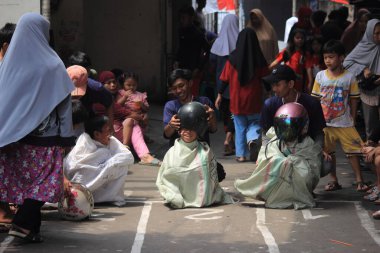 Editör fotoğrafı, Endonezya, 17 Ağustos 2022, Hut Ri, Kemerdekaan 'da Doğu Jakarta eğlence oyunu, çanta kullanarak atlayan çocuklar.