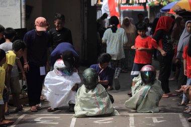 Editör fotoğrafı, Endonezya, 17 Ağustos 2022, Hut Ri, Kemerdekaan 'da Doğu Jakarta eğlence oyunu, çanta kullanarak atlayan çocuklar.