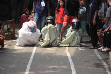Editör fotoğrafı, Endonezya, 17 Ağustos 2022, Hut Ri, Kemerdekaan 'da Doğu Jakarta eğlence oyunu, çanta kullanarak atlayan çocuklar.