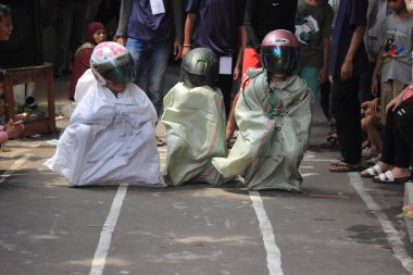 Editör fotoğrafı, Endonezya, 17 Ağustos 2022, Hut Ri, Kemerdekaan 'da Doğu Jakarta eğlence oyunu, çanta kullanarak atlayan çocuklar.