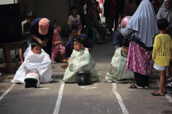 Editör fotoğrafı, Endonezya, 17 Ağustos 2022, Hut Ri, Kemerdekaan 'da Doğu Jakarta eğlence oyunu, çanta kullanarak atlayan çocuklar.