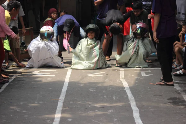 Editör fotoğrafı, Endonezya, 17 Ağustos 2022, Hut Ri, Kemerdekaan 'da Doğu Jakarta eğlence oyunu, çanta kullanarak atlayan çocuklar.