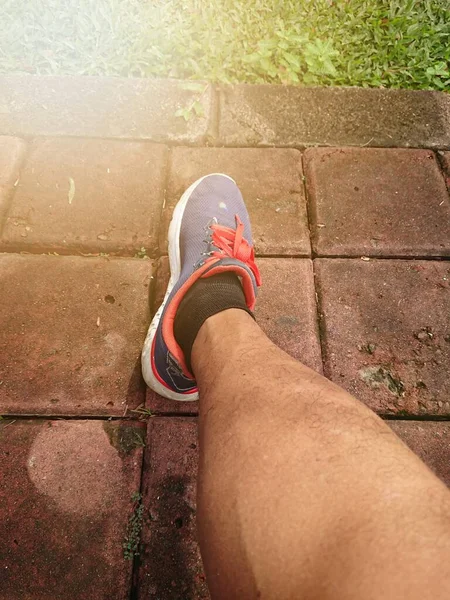 Close up, Big Man Leg Using Blue Sport Shoes, with lens or sun shine flare