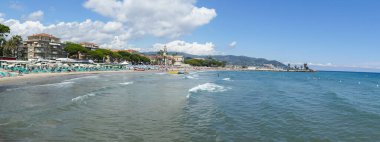 Diano Marina, İtalya - 10-07-2021: Arka planda güzel bir kilisesi olan Diano Marina plajı