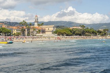 Diano Marina, İtalya - 10-07-2021: Arka planda güzel bir kilisesi olan Diano Marina plajı